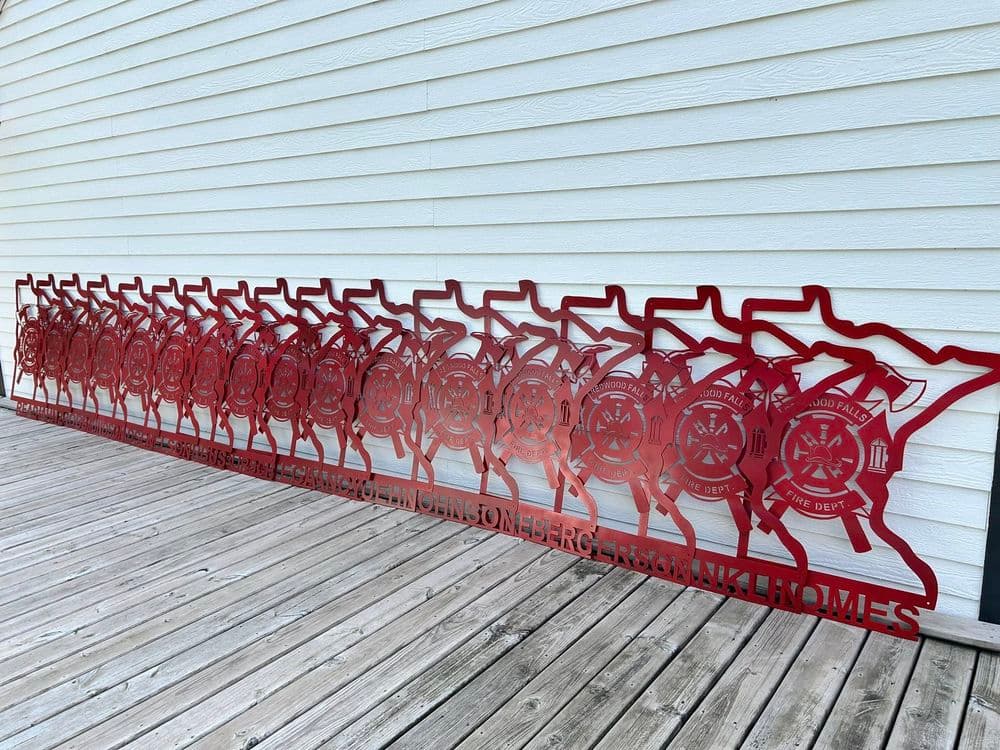 Metal fire department display on wooden deck featuring multiple red fire department logos.