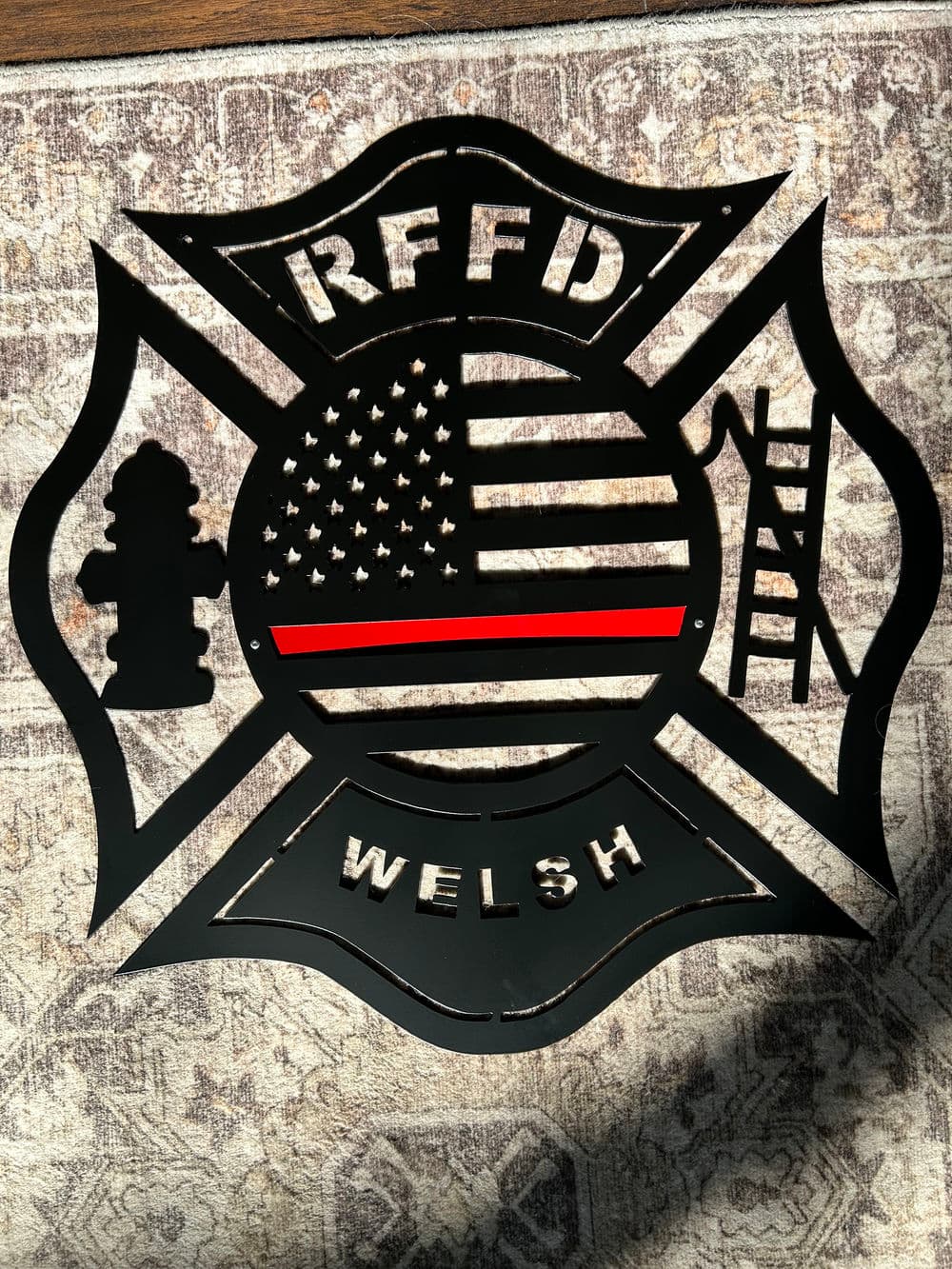 Firefighter emblem featuring American flag, fire hydrant, and ladder with 'Welsh' inscription.