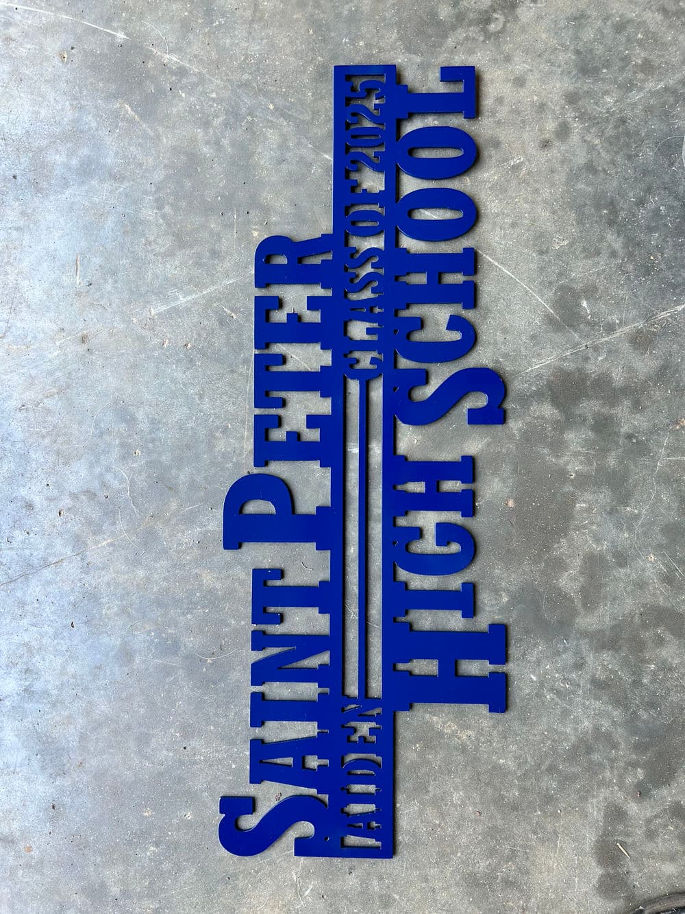 Saint Peter High School class of 2023 sign in blue metal lettering on a gray background.