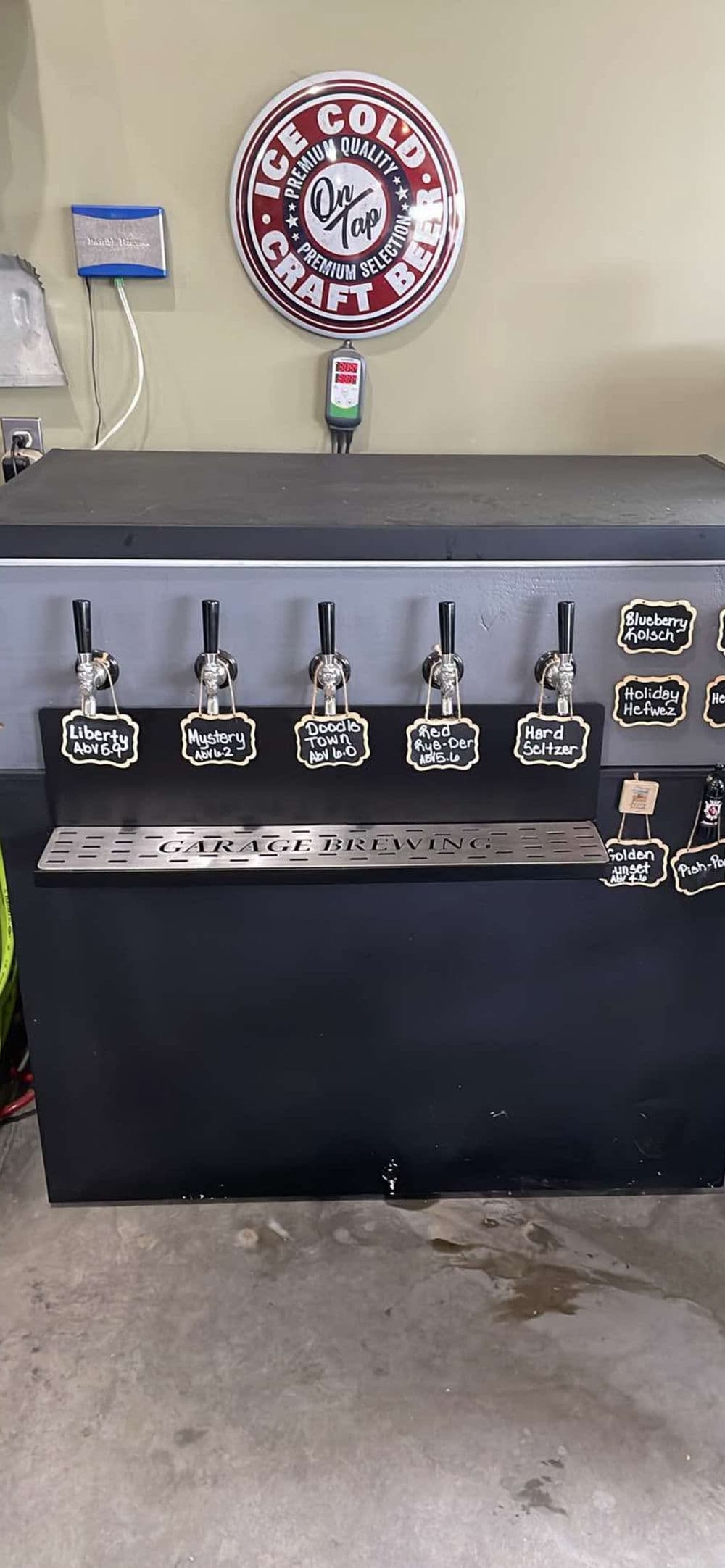 Craft beer tap system with six faucets for pouring various flavors and a decorative sign.