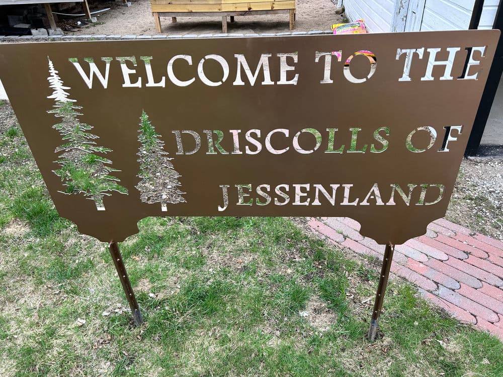 Welcome sign for the Driscolls of Jessenland featuring pine tree illustrations.