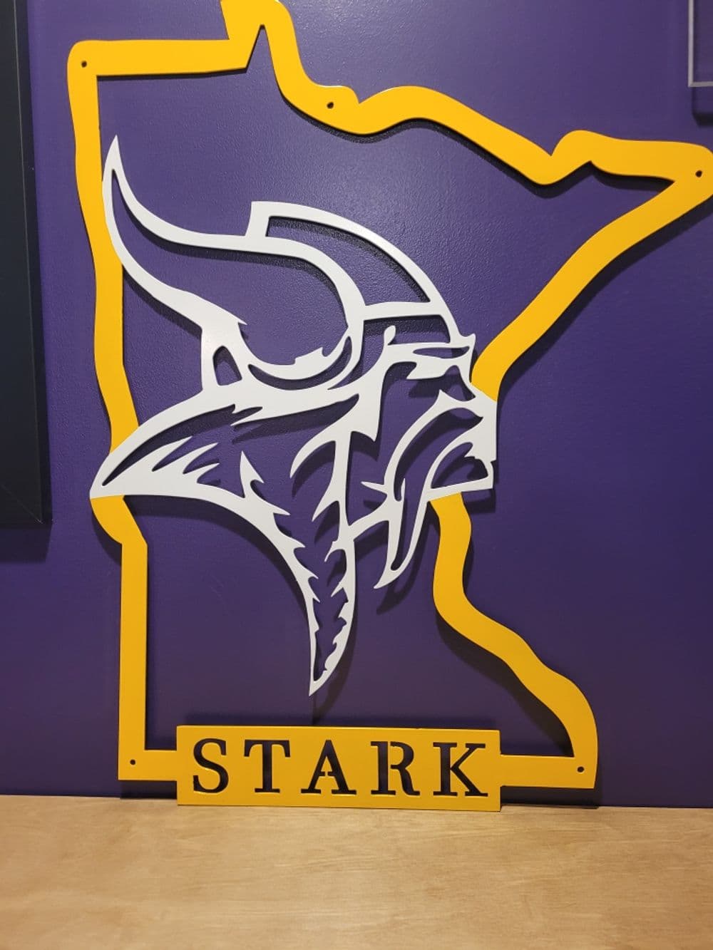 Purple and yellow Minnesota Vikings logo with "STARK" at the bottom, framed by the state outline.
